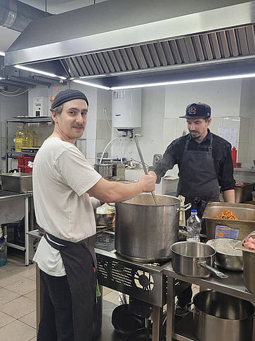 Nikita rührt in einem großen Kochtopf.
