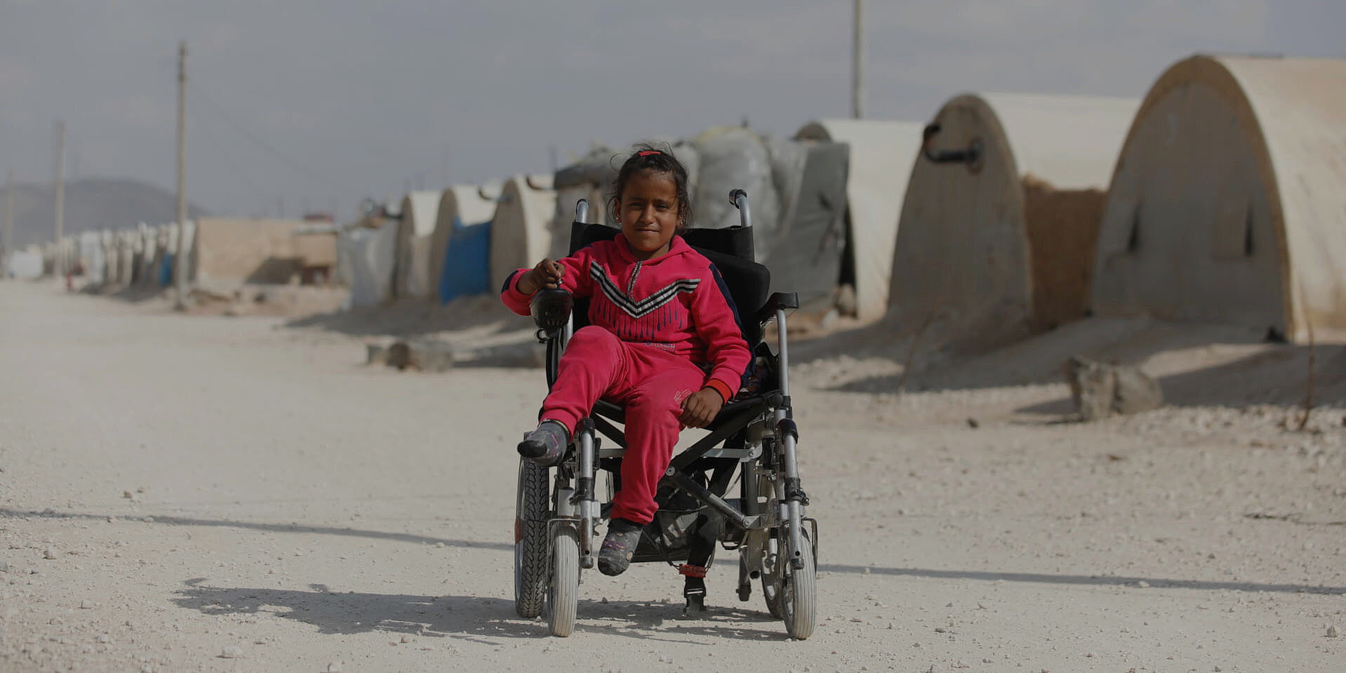 Bushra sitzt in ihrem Rollstuhl in einem Flüchtlingscamp in Syrien