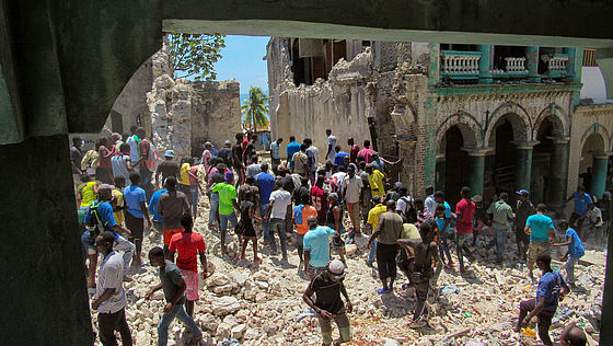 Viele Menschen in Haiti laufen durch die Trümmer des Erdbebens.