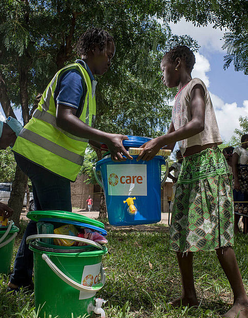 Ein CARE-Helfer überreicht ein Hygiene-Paket an eine von Zyklon Idai betroffene Frau