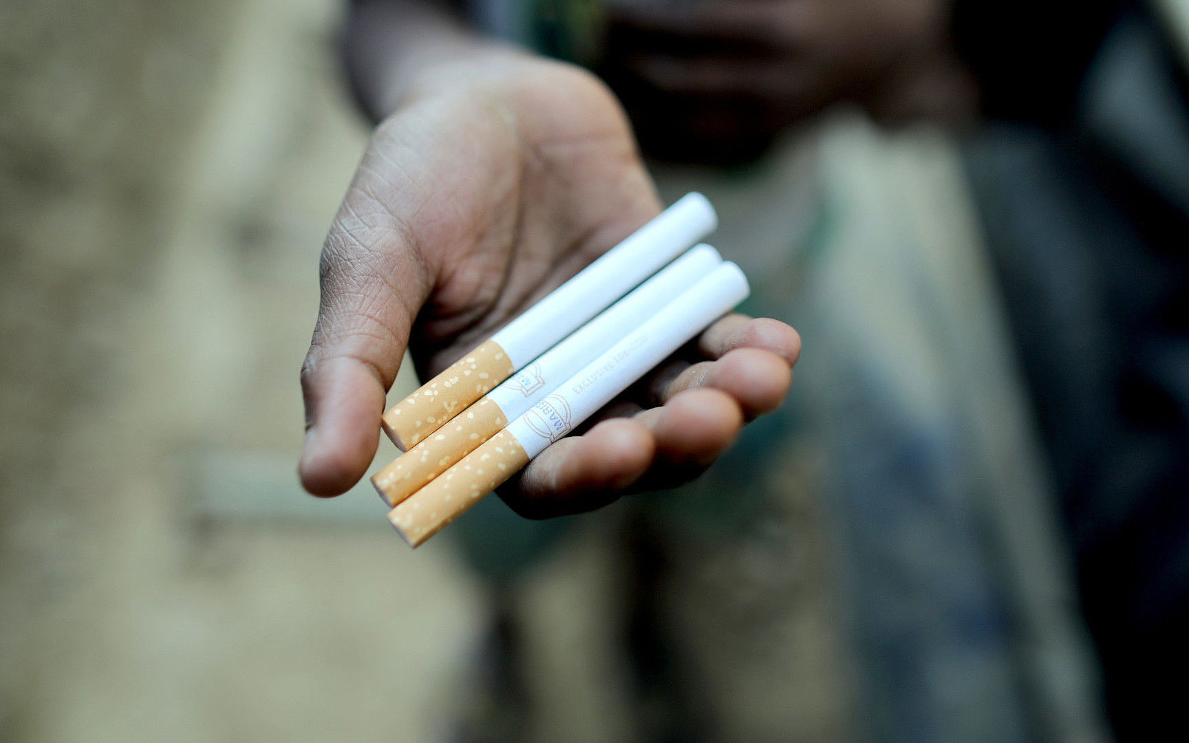 Omar hält Zigaretten in der Hand, die er im Flüchtlingscamp verkauft.