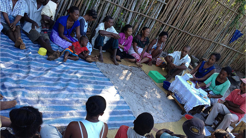 Die Teilnehmer:innen der Kleinspargruppe in Bemenaka sitzen zusammen bei einem ihrer wöchentlichen Treffen