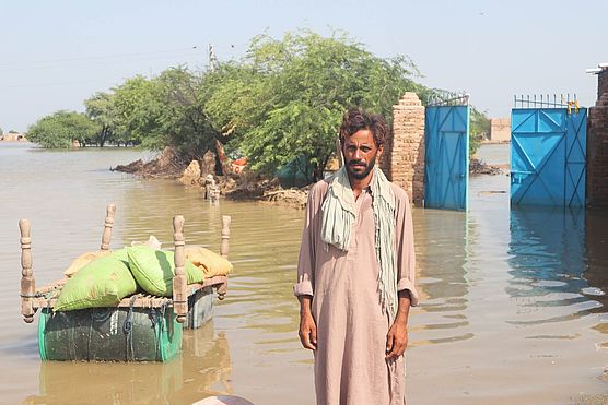 Ein Mann steht im Wasser nach der Überschwemmung in Pakistan