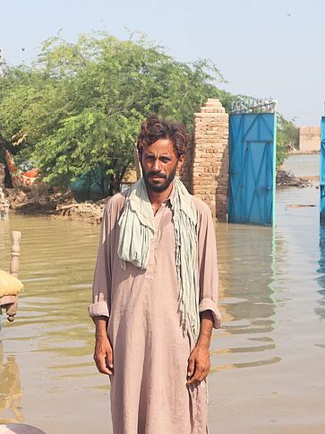 Ein Mann steht im Wasser nach der Überschwemmung in Pakistan