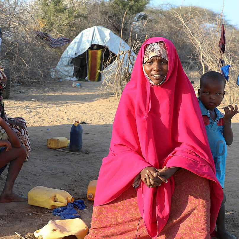 Amina sitzt mit ihren Kindern vor einem Zelt in einem Flüchtlingscamp in Somalia