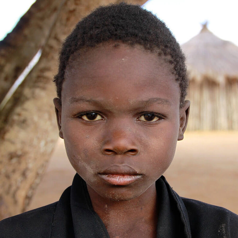 Portrait eines Mädchens aus Mosambik, das traurig in die Kamera guckt
