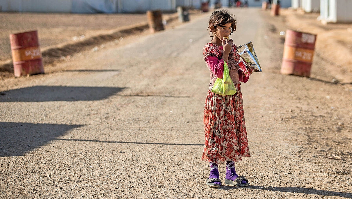 Ein syrisches Mädchen steht auf einer Straße im Azraq-Flüchtlingscamp in Jordanien und isst Chips