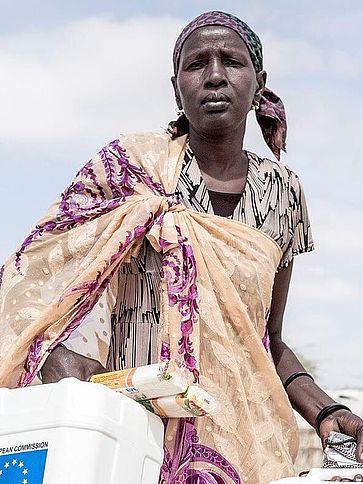 Eine Frau in Kenia trägt zwei große Wasserkanister