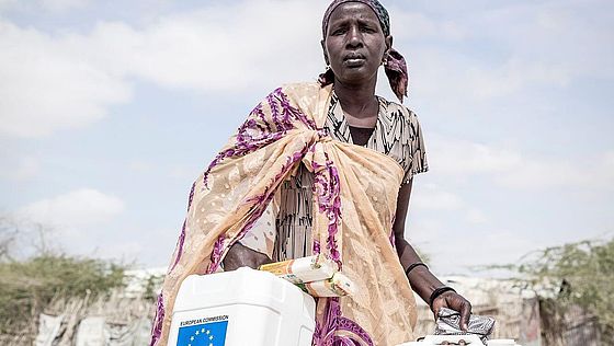 Eine Frau in Kenia trägt zwei große Wasserkanister