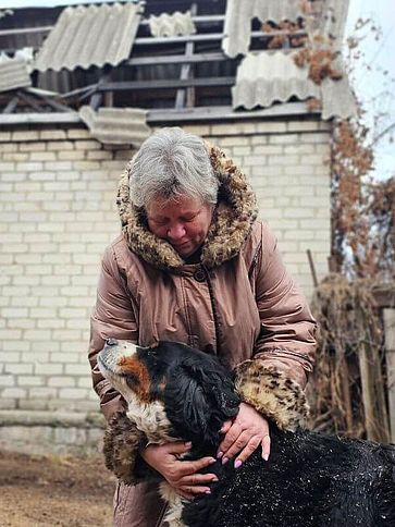 Olga kuschelt mit einem Hund.