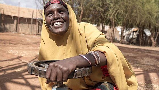 Somalierin Hado schraubt lachend an einem Wassertank