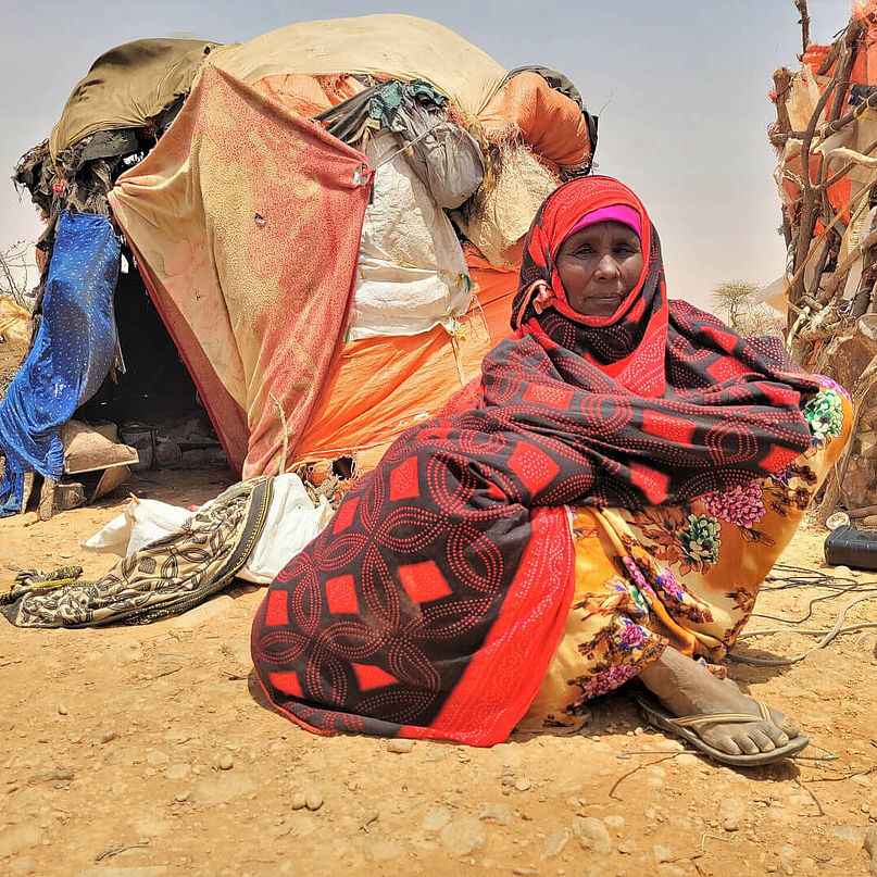 Aisha aus Somalia sitzt vor ihrem Zelt.