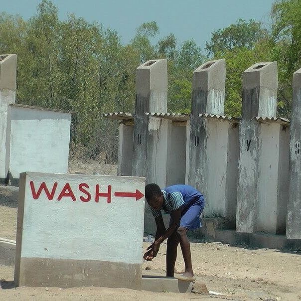 Eine Schülerin wäscht ihre Hände an einem von CARE installierten Wasserhahn