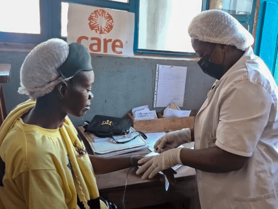 Behandlung einer Frau im Ebola-Gebiet Eine Patientin wird von einer CARE-Helferin in der DR Kongo im Ebola-Gebiet behandelt.