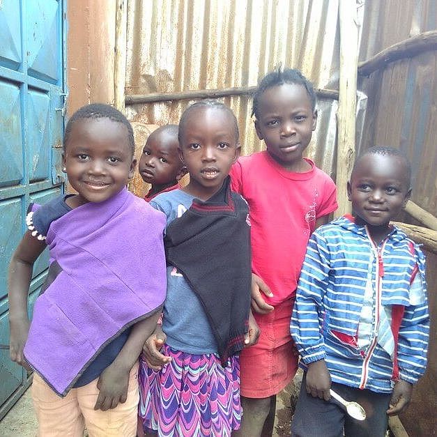 Fünf Kinder im Korogocho-Slum in Nairobi in Kenia blicken in die Kamera