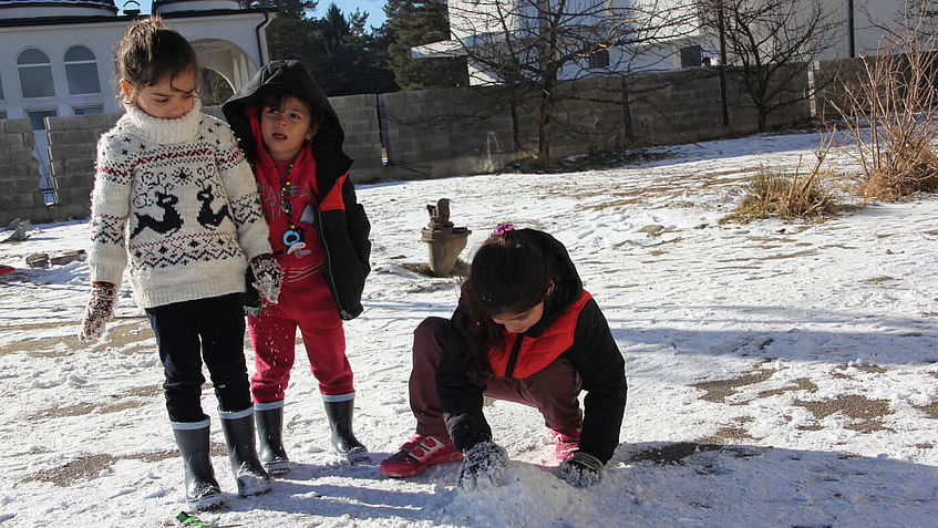 Flüchtlingskinder in Serbien spielen im Schnee.