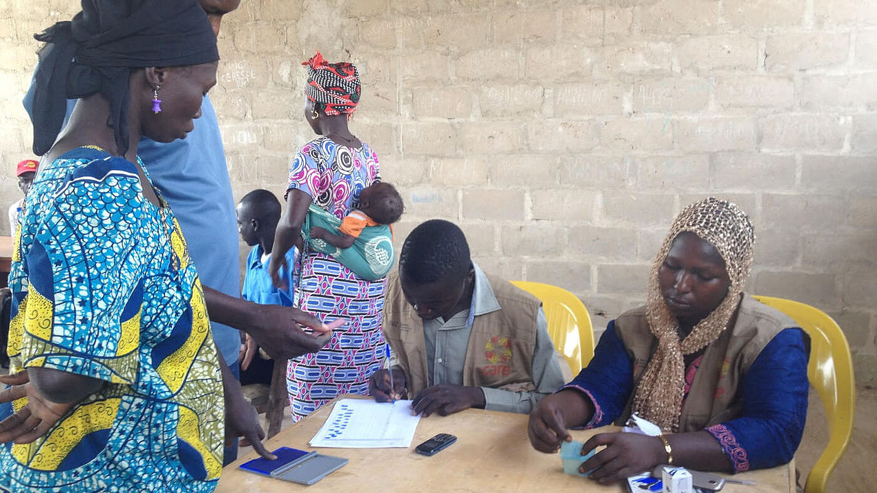 CARE-Helfer:innen verteilen Bargeldschecks an Geflüchtete und Dorfbewohner:innen im Tschad.