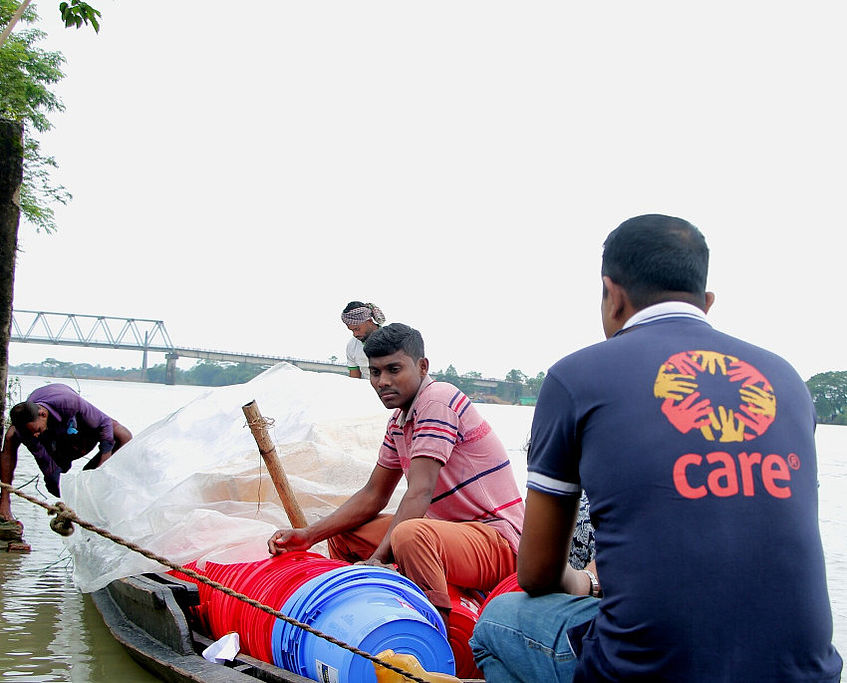 Ein CARE Mitarbeiter in Bangladesch fährt auf einem Boot.