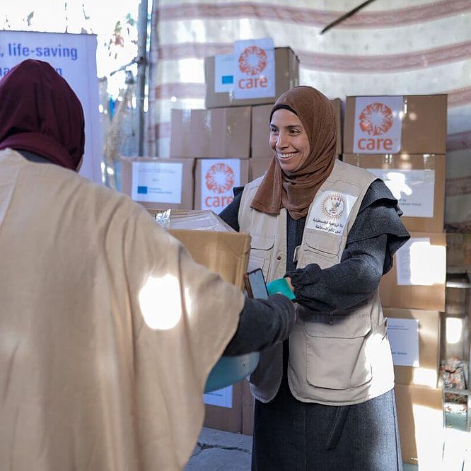 Helferin einer CARE-Partnerorganisation verteilt Hilfsgueter.