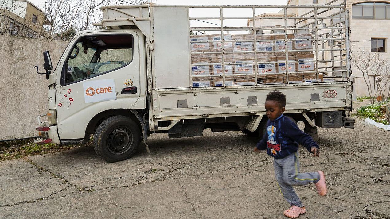 Ein Junge vor Lkw Ein Junge läuft vor einem mit Hilfsgütern beladenen Lkw.