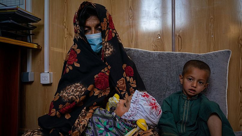 Aisha sitzt mit ihren zwei Kindern zusammen.