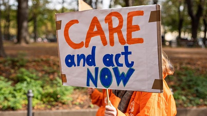 Ein Protestplakat mit der Aufschrift: "Care and act now".