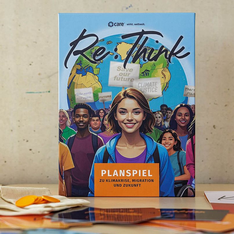 Die Box des Planspiels mit aufgereihten Spielkarten davor