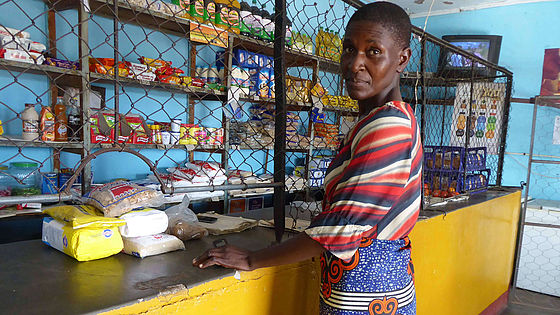 Eine Mutter steht in einem Geschäft und kauft Lebensmittel