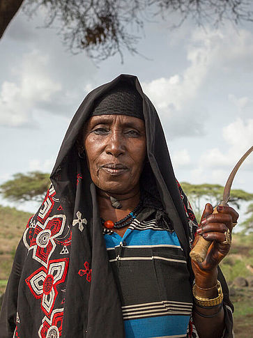 Eine ältere äthiopische Frau hält eine Sichel in der Hand