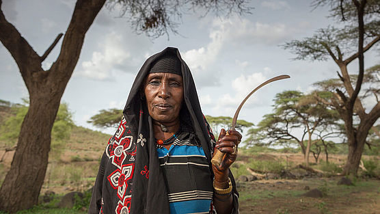 Eine ältere äthiopische Frau hält eine Sichel in der Hand