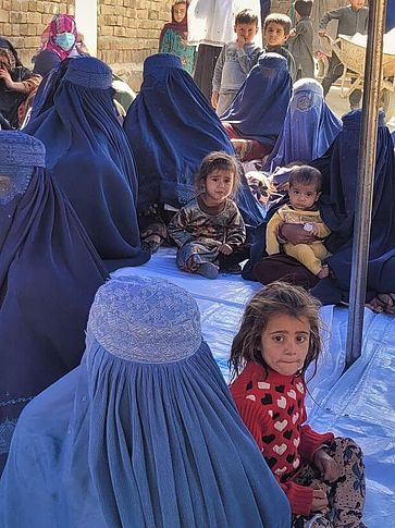 Frauen und Kinder aus Afghanistan sitzend auf dem Boden