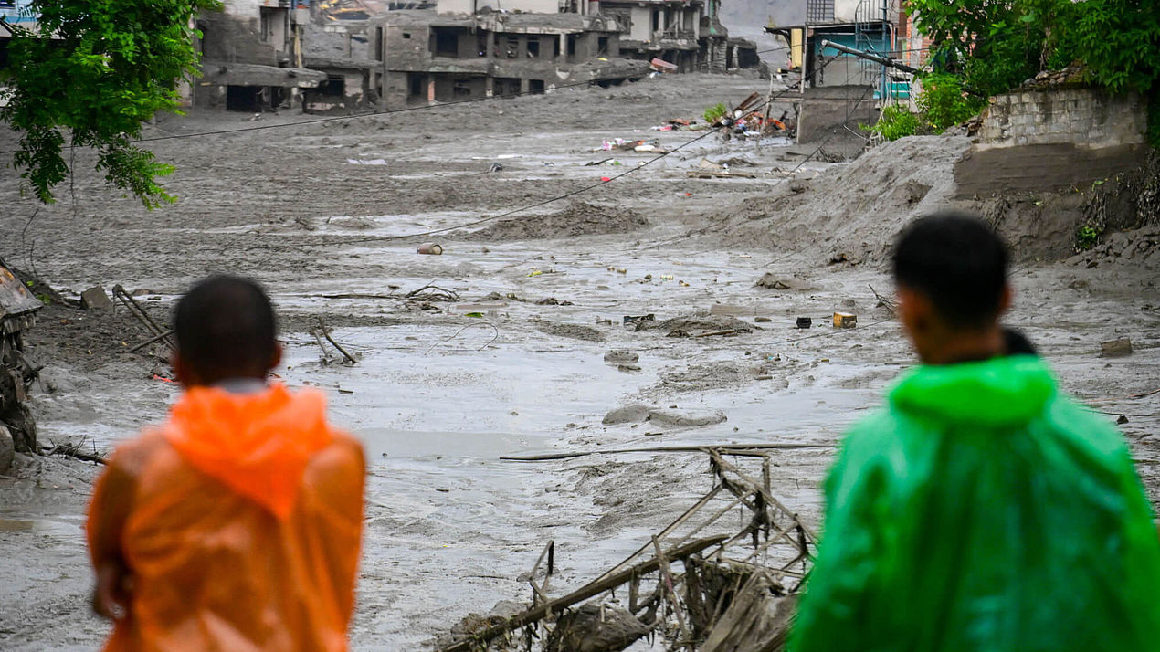 Betroffene der Sturzflut in Nepal Zwei Menschen stehen nach der Sturzflut in Nepal vor ihren zerstörten Häusern.