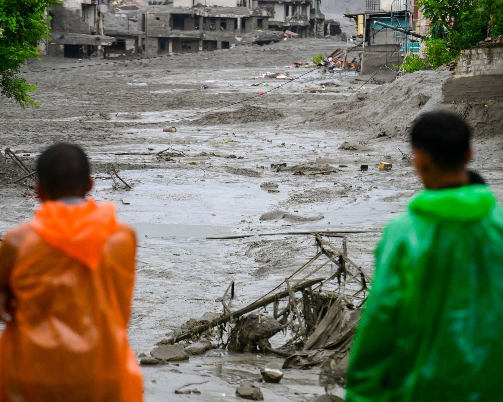 Zwei Menschen stehen nach der Sturzflut in Nepal vor ihren zerstörten Häusern.
