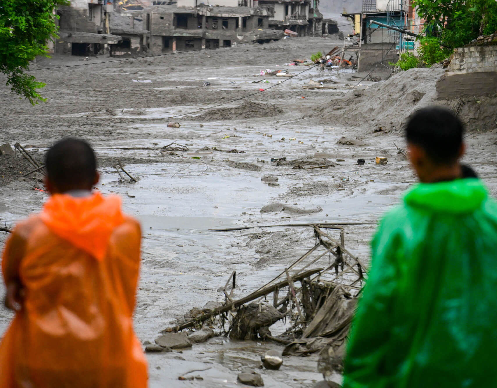 Zwei Menschen stehen nach der Sturzflut in Nepal vor ihren zerstörten Häusern.