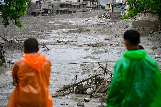Betroffene der Sturzflut in Nepal Zwei Menschen stehen nach der Sturzflut in Nepal vor ihren zerstörten Häusern.
