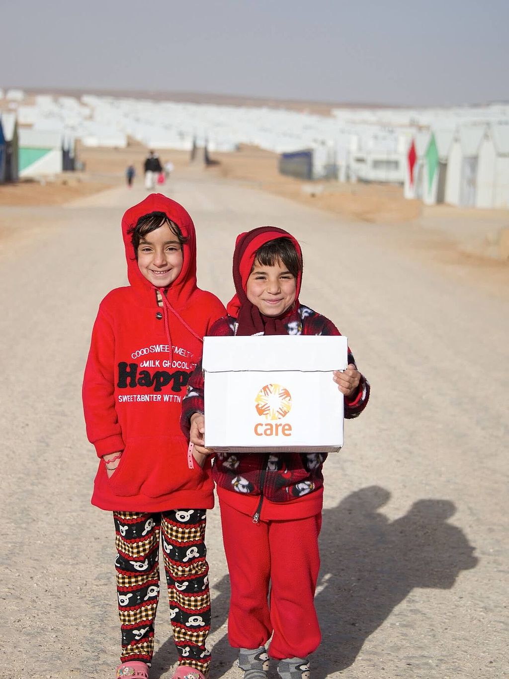 Zwei Mädchen im Flüchtlingslager in Jordanien mit CARE-Paket