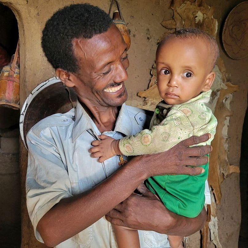 Mann aus Äthiopien mit Kind auf dem Arm