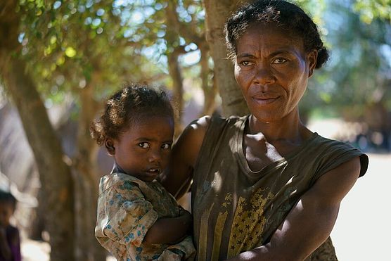 Die 35-jährige Julienne in Madagaskar trägt ihr Kind auf dem Arm.