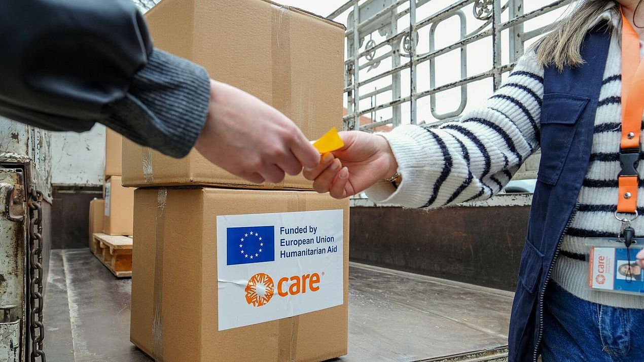 Person holt CARE-Paket ab Eine Person gibt eine Marke ab, um ein CARE-Paket abholen zu können.