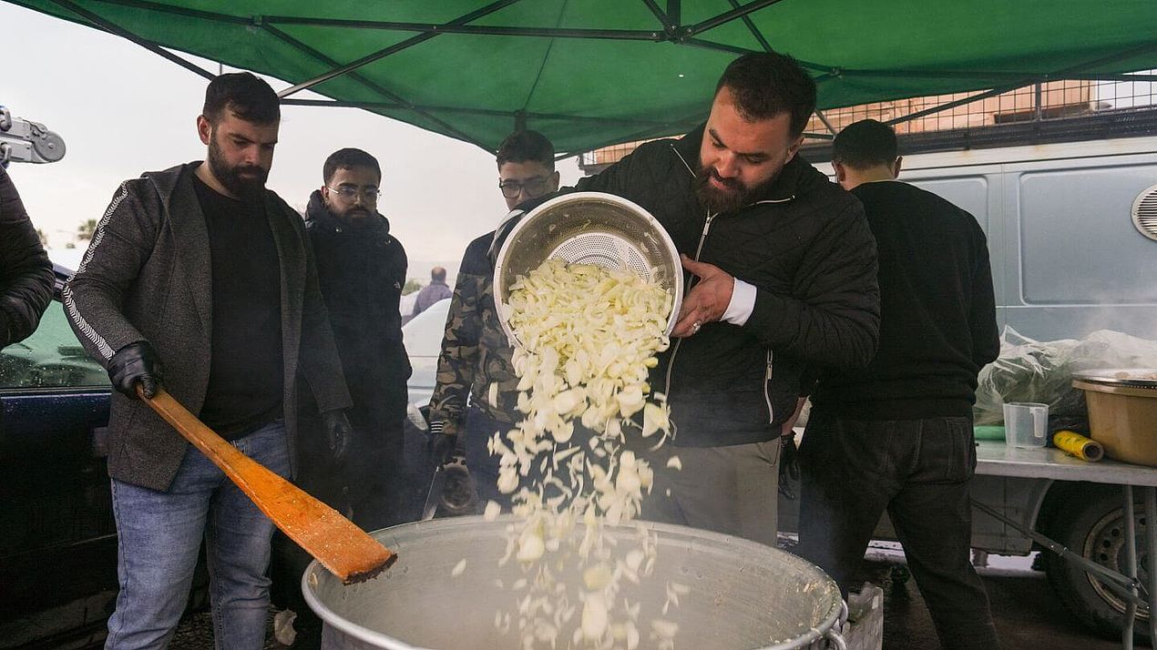 Mann befüllt Kochtopf Ein Mann füllt Zwiebelringe in einen großen Kochtopf.