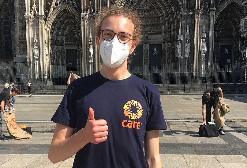 Bundesfreiwilliger Severin Weitz steht mit einer Maske vor dem Kölner Dom 
