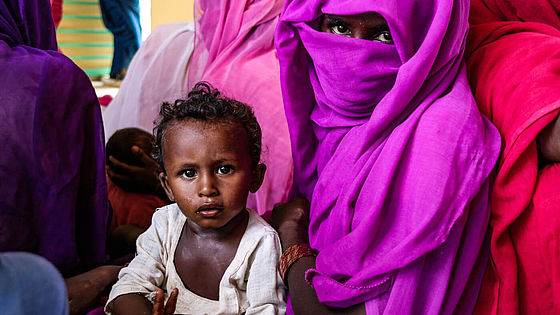 Die 21-jährige Nafisa wartet mit ihrem zweijährigen Kind in einem CARE-Ernährungszentrum.
