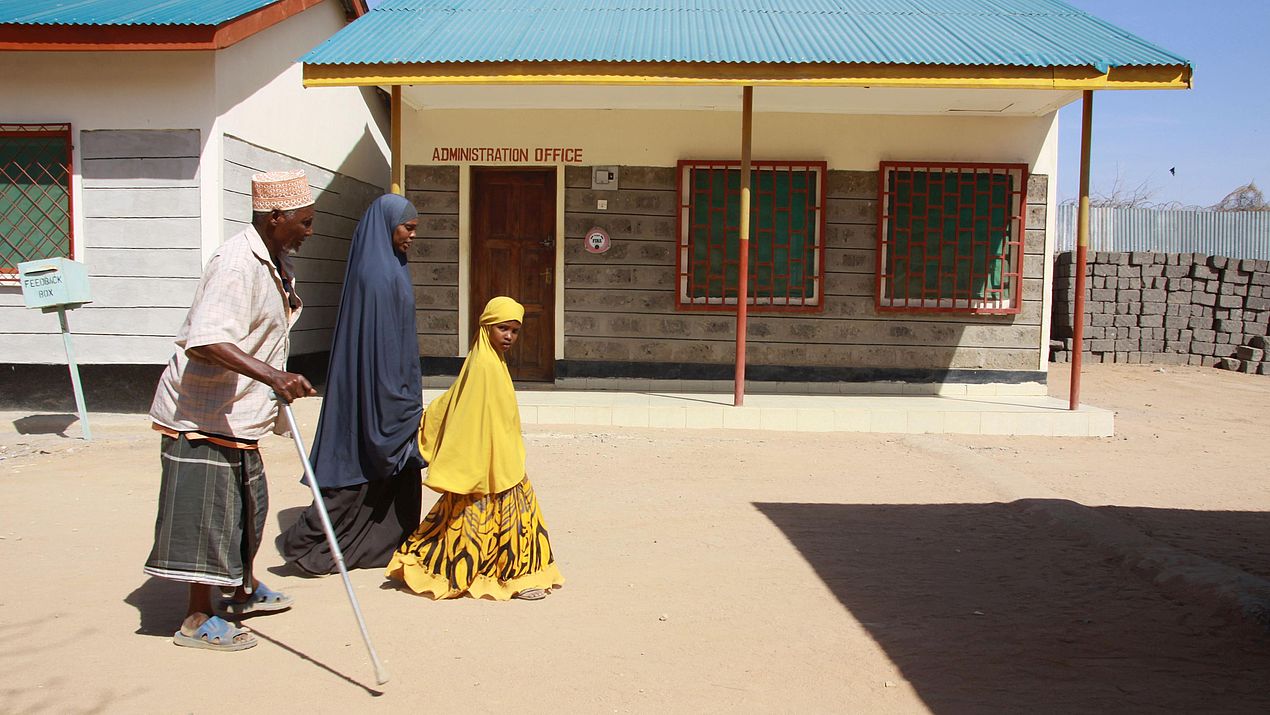 Eine somalische Familie geht an einem CARE Beratungszentrum vorbei.