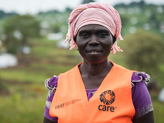 Eine Freiwillige in Uganda trägt eine orange CARE-Weste