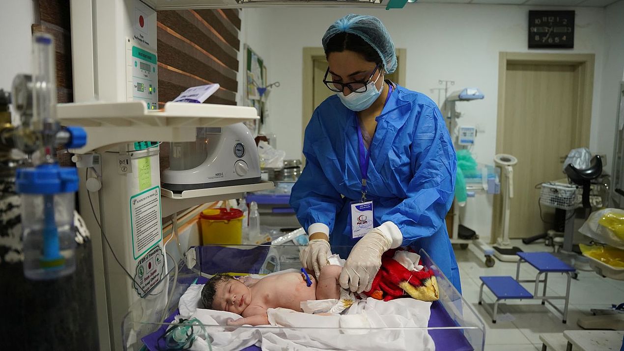 Eine Hebamme im Irak untersucht ein Neugeborenes.