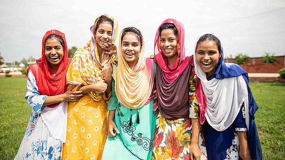 Fünf Frauen aus Bangladesch stehen zusammen Fünf Teilnehmerinnen der CARE-Schulung in Bangladesch zum Thema "Frauen stärken" stehen zusammen und lachen