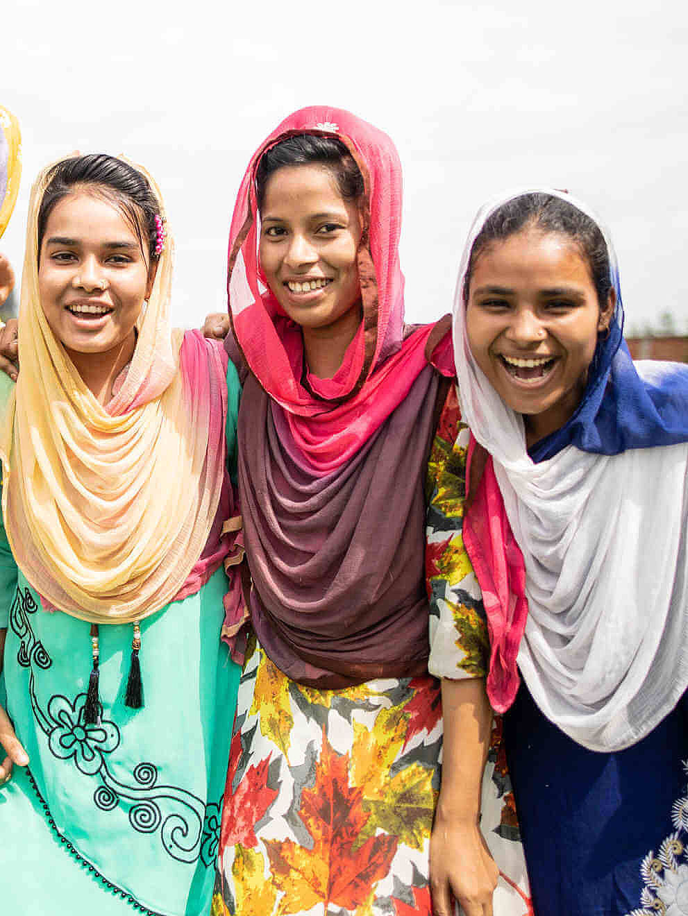 Fünf Teilnehmerinnen der CARE-Schulung in Bangladesch zum Thema "Frauen stärken" stehen zusammen und lachen