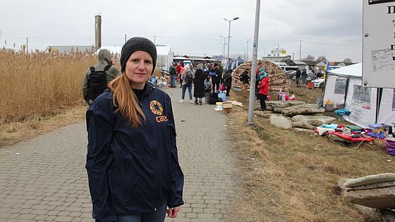 CARE-Helferin Ninja Taprogge blickt in die Kamera an einem polnisch-ukrainischen Grenzübergang.