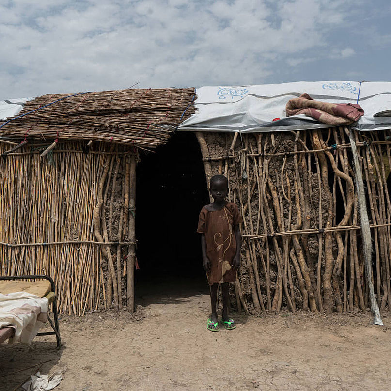 Die fünfjährige Nyahok steht vor der Hütte, in der sie mit ihrer Familie lebt.