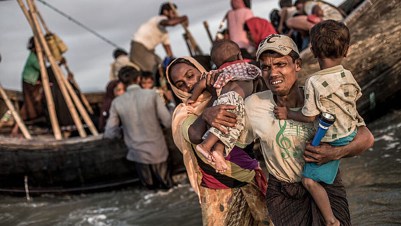 Eine geflüchtete Familie aus Myanmar gehen in Bangladesch von Bord eines Schiffes